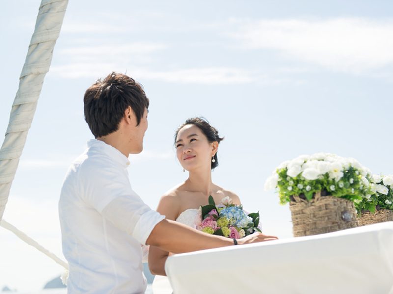 在游艇甲板上相视的新郎新娘